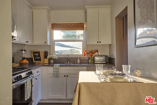 a kitchen with kitchen island granite countertop a sink cabinets and window
