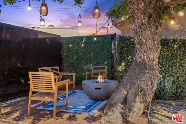 a backyard of a house with barbeque oven and outdoor seating