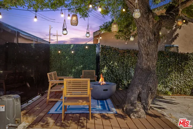 a backyard of a house with wooden floor and large trees