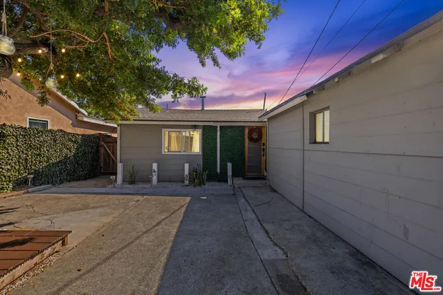 a front view of a house with a yard and potted plants