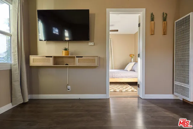 a view of a livingroom with wooden floor and a flat screen tv