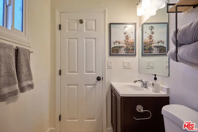 a bathroom with a sink and mirror with toilet