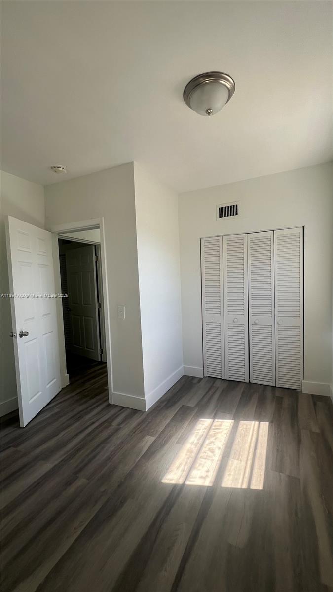413 Northwest 33rd Street, Unit B Miami, FL 33127 - Photo 12 of 13 an empty room with wooden floor and windows