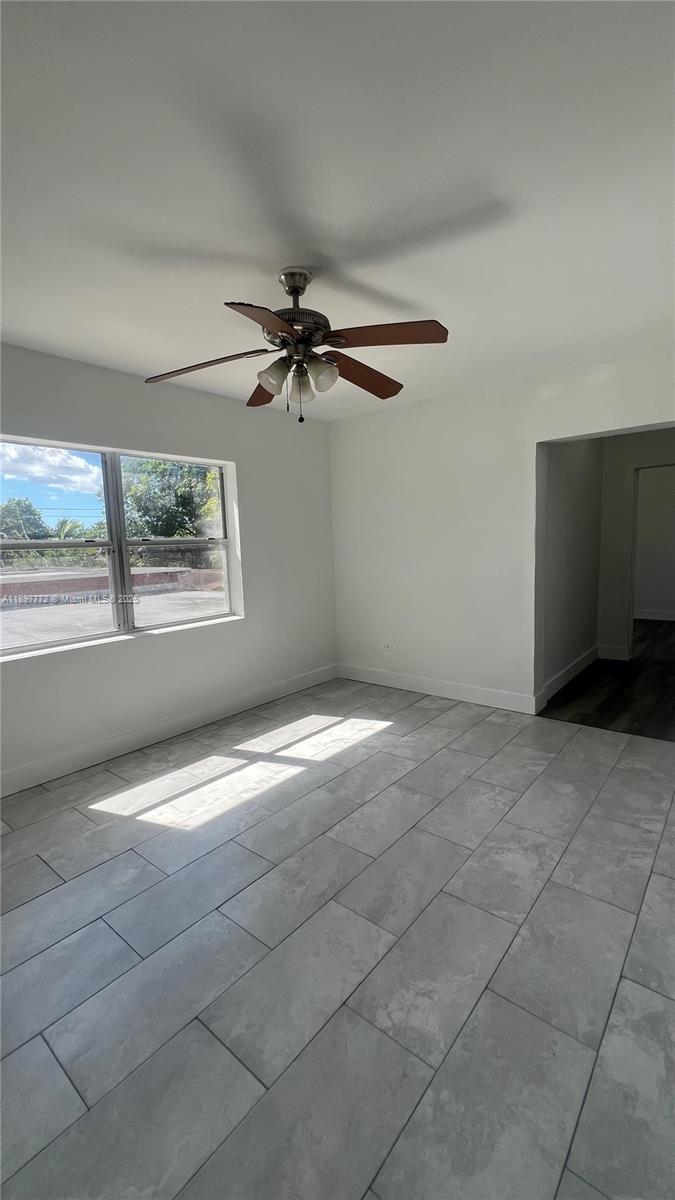 413 Northwest 33rd Street, Unit B Miami, FL 33127 - Photo 6 of 13 a view of a livingroom with a ceiling fan and window