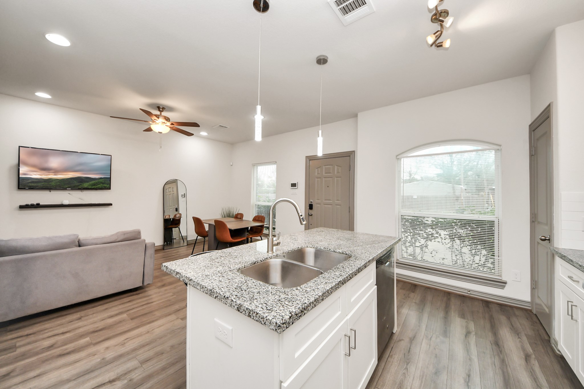 5334 Pershing Street Houston, TX 77033 - Photo 34 of 43 a kitchen with granite countertop a sink dishwasher a dining table and chairs with wooden floor
