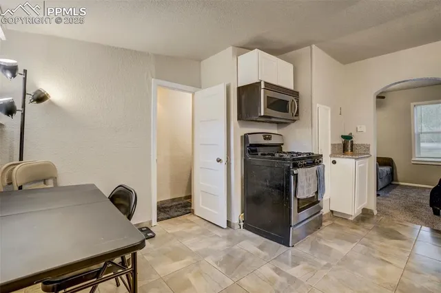 a kitchen with stainless steel appliances a stove a microwave a sink a refrigerator and cabinets