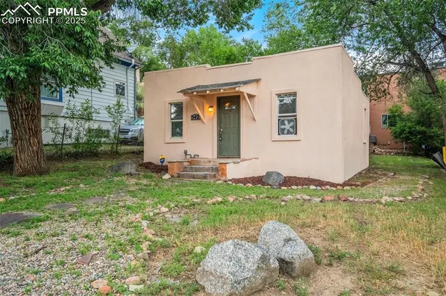 a view of a white house with a yard
