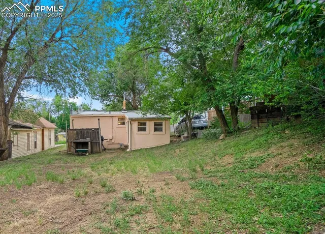 a view of a house with a yard and tree