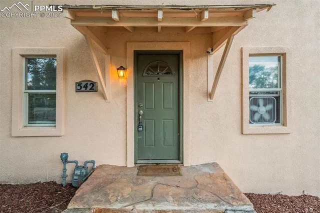 a view of a hallway with windows and chandelier