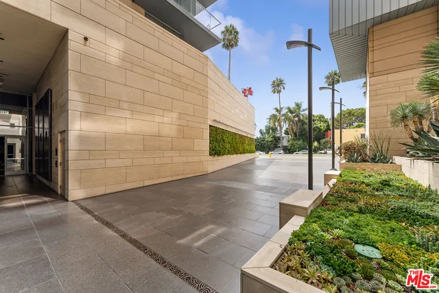 a front view of multi story residential apartment building with yard and traffic signal