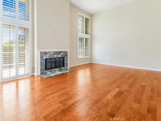 a view of empty room with wooden floor and fireplace