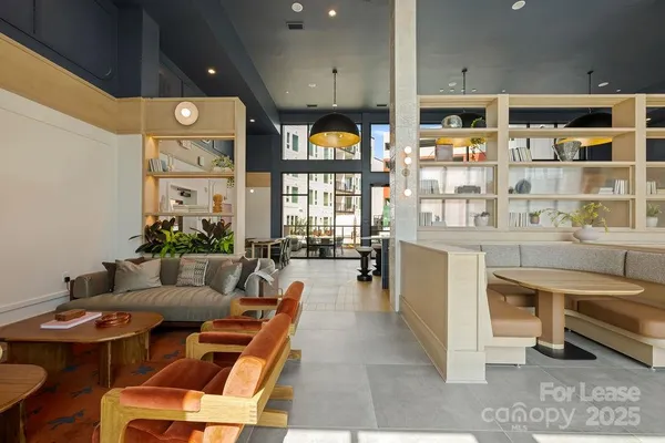 a living room with furniture a table and kitchen view
