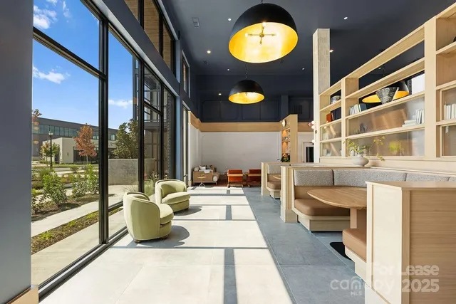 a living room with furniture large windows and a chandelier