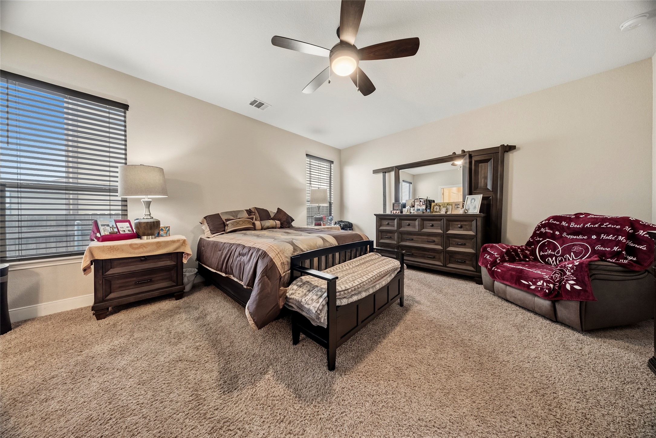 105 West Point Way Elgin, TX 78621 - Photo 11 of 27 Carpeted bedroom featuring neutral wall tones, multiple windows with horizontal blinds, a ceiling fan with integrated lighting, and ample natural light