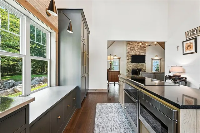 a large kitchen with kitchen island a large window a sink and stainless steel appliances