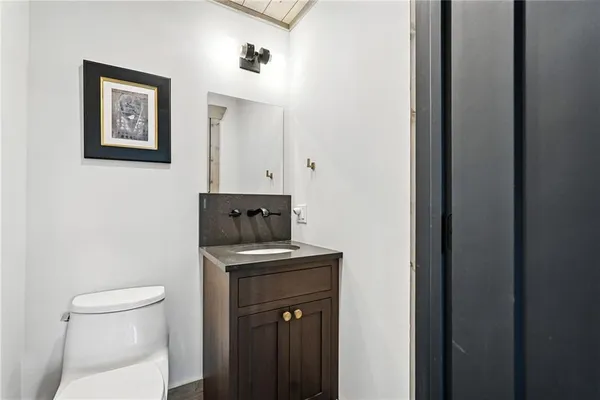 a bathroom with a toilet a sink and mirror