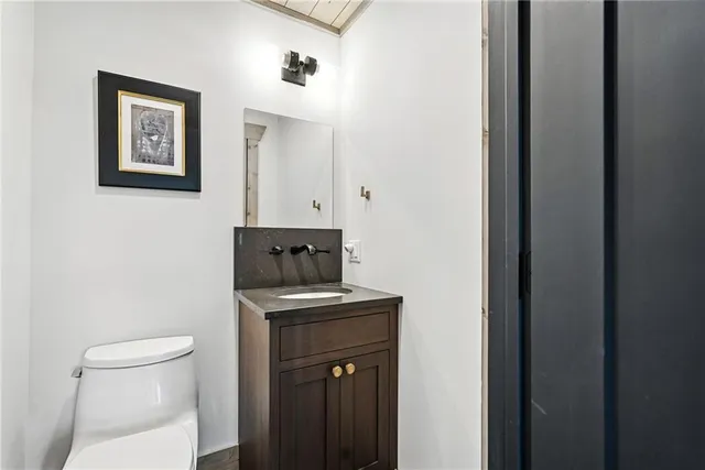 a bathroom with a toilet a sink and mirror