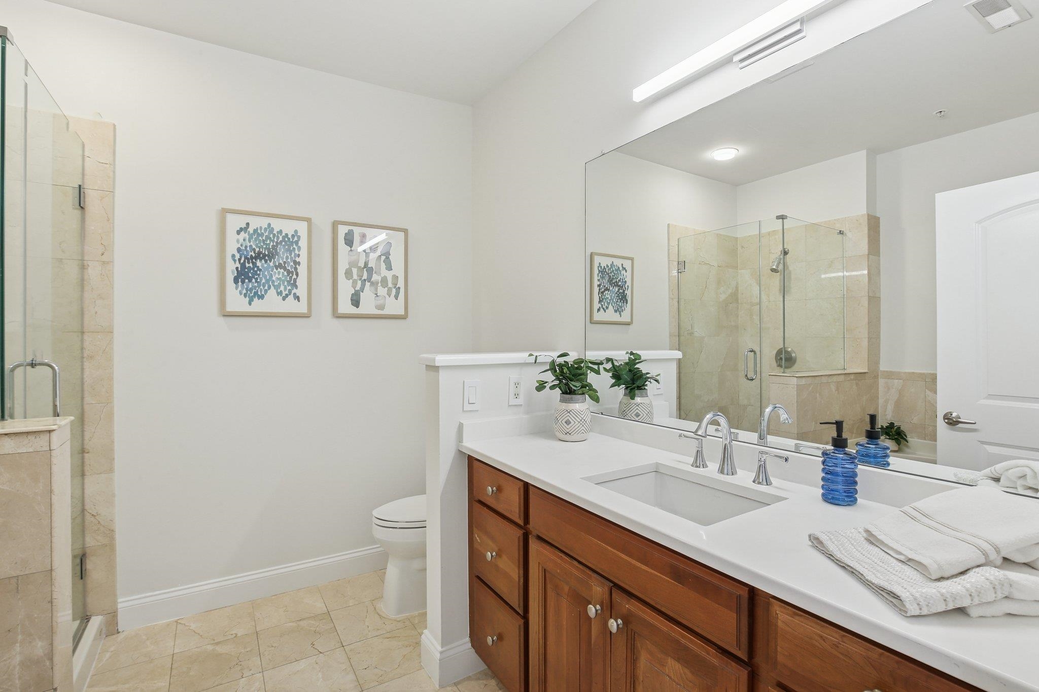 22 Ave At Port Imperial, Unit 208 West New York, NJ 07093 - Photo 14 of 34 a bathroom with a granite countertop sink a toilet a large mirror and shower