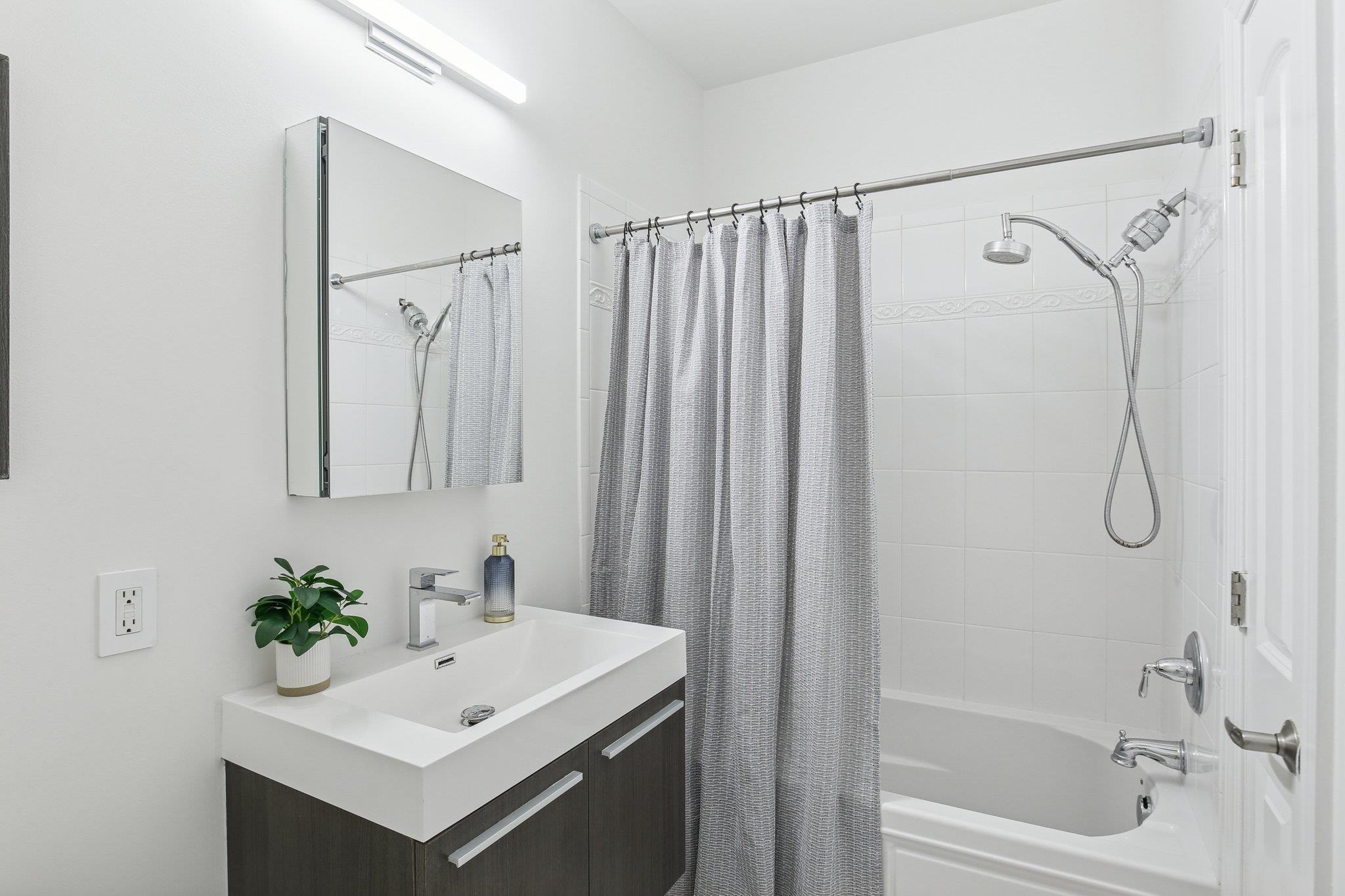 22 Ave At Port Imperial, Unit 208 West New York, NJ 07093 - Photo 26 of 34 a bathroom with a sink a mirror a vanity and a shower