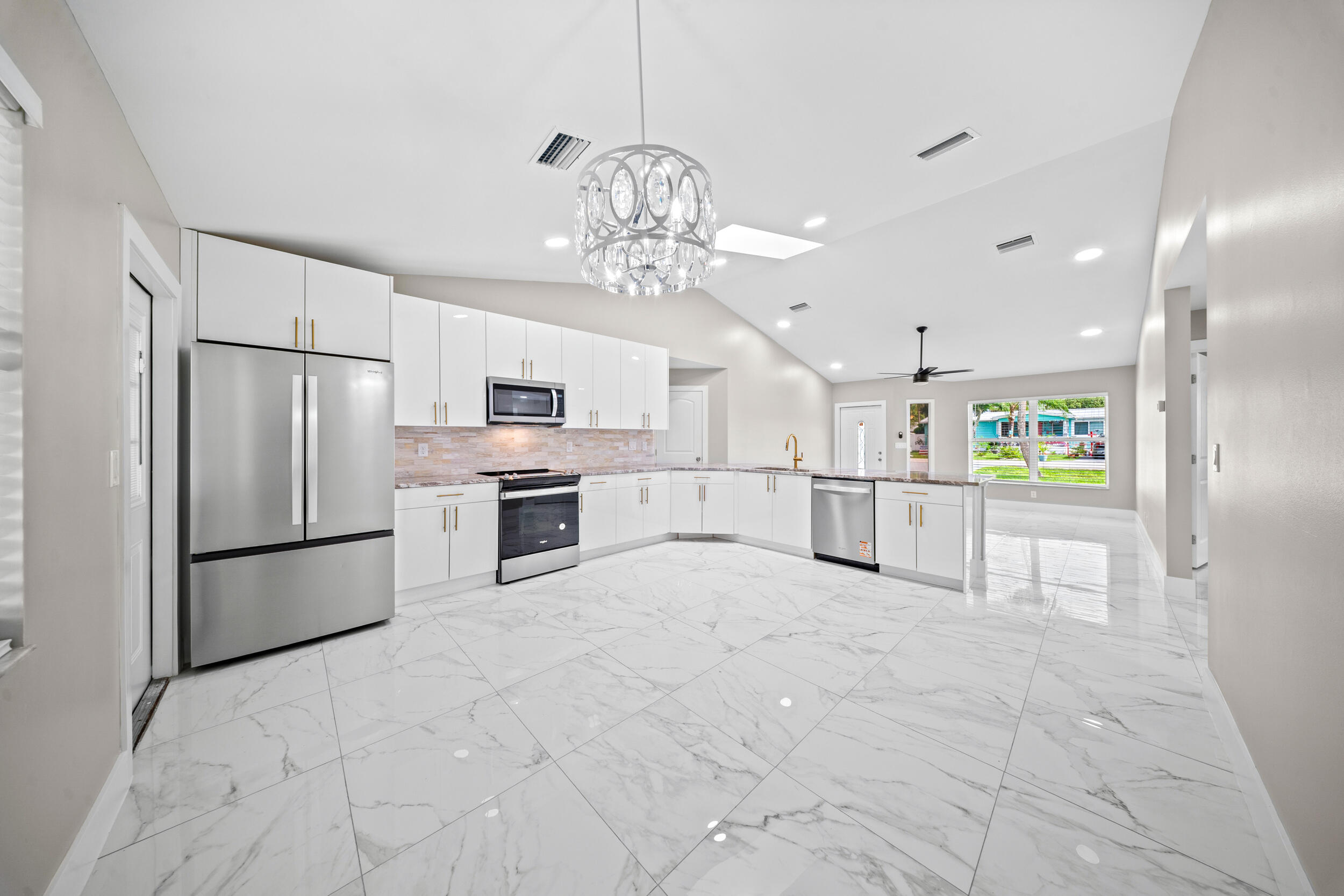 1627 Southeast Monroe Street Stuart, FL 34997 - Photo 11 of 33 a large white kitchen with cabinets and stainless steel appliances