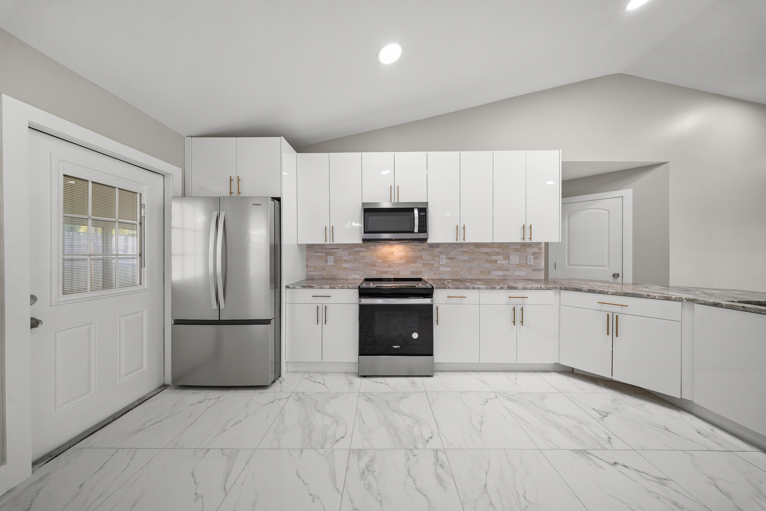 1627 Southeast Monroe Street Stuart, FL 34997 - Photo 12 of 33 a kitchen with granite countertop white cabinets and stainless steel appliances