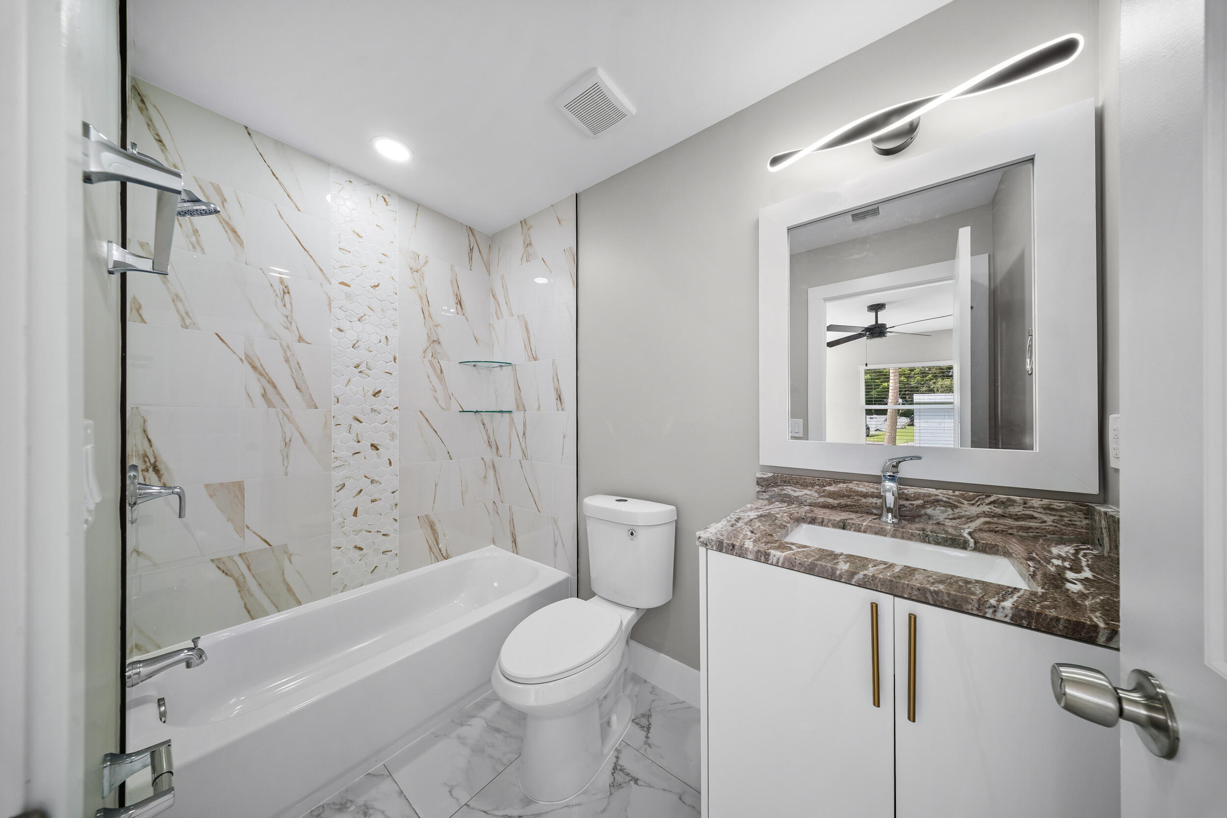 1627 Southeast Monroe Street Stuart, FL 34997 - Photo 16 of 33 a bathroom with a granite countertop sink toilet and shower