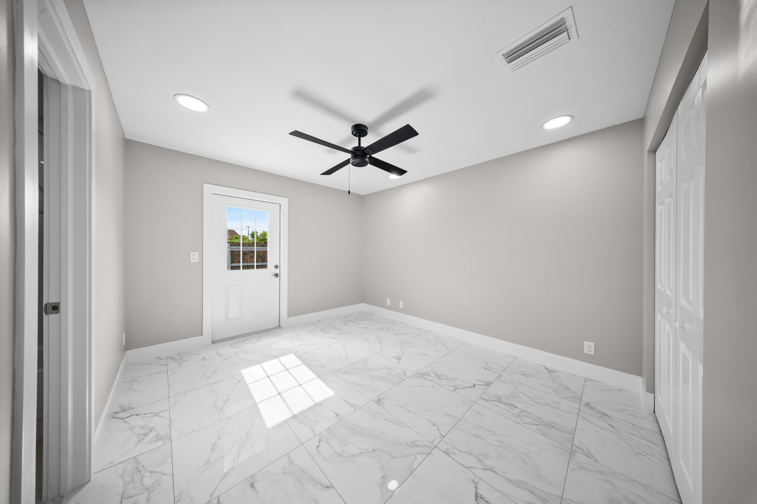 1627 Southeast Monroe Street Stuart, FL 34997 - Photo 17 of 33 an empty room with windows and ceiling fan