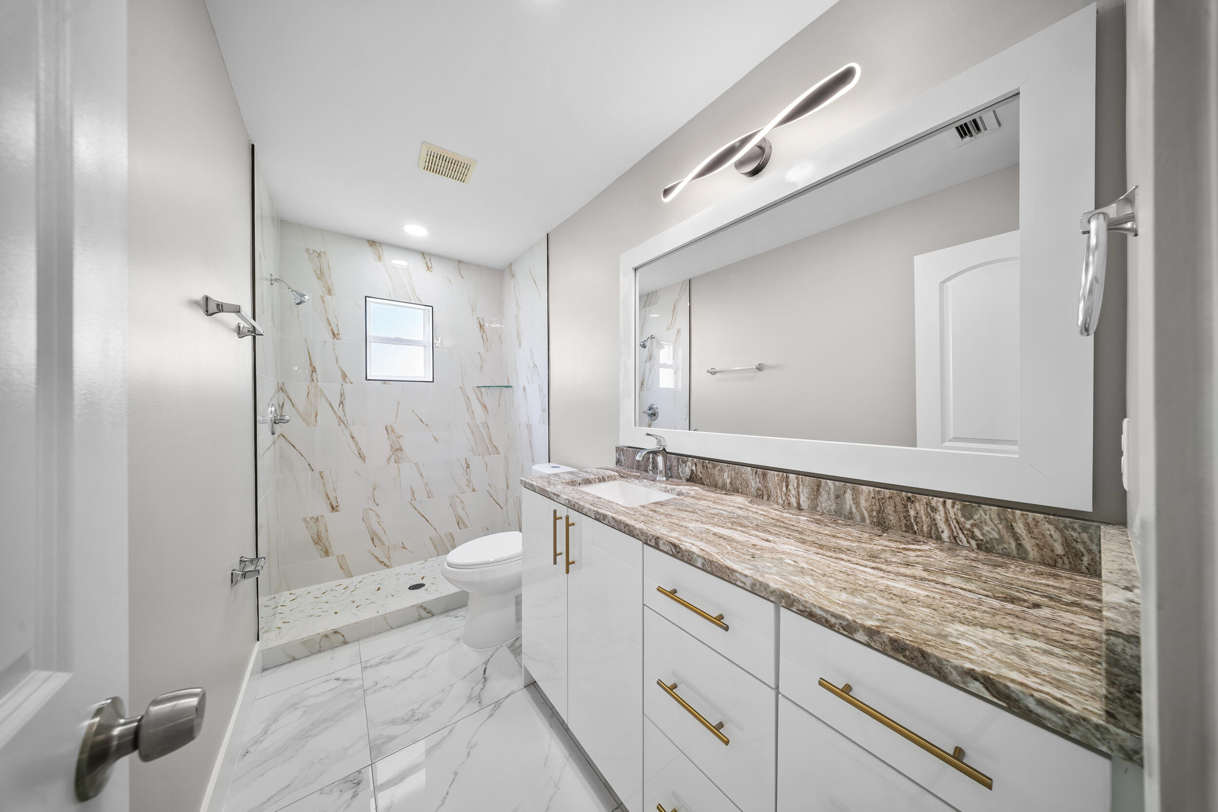 1627 Southeast Monroe Street Stuart, FL 34997 - Photo 22 of 33 a spacious bathroom with a granite countertop sink mirror and a bathtub