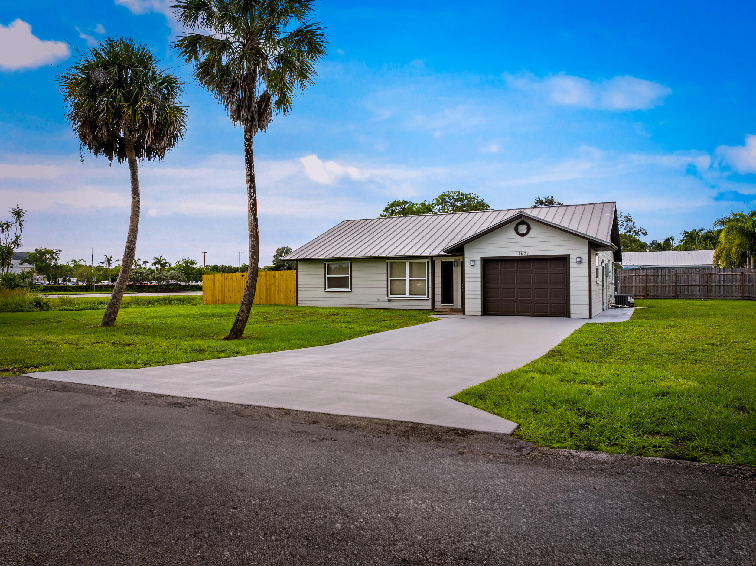 1627 Southeast Monroe Street Stuart, FL 34997 - Photo 3 of 33 a front view of a house with a garden and yard