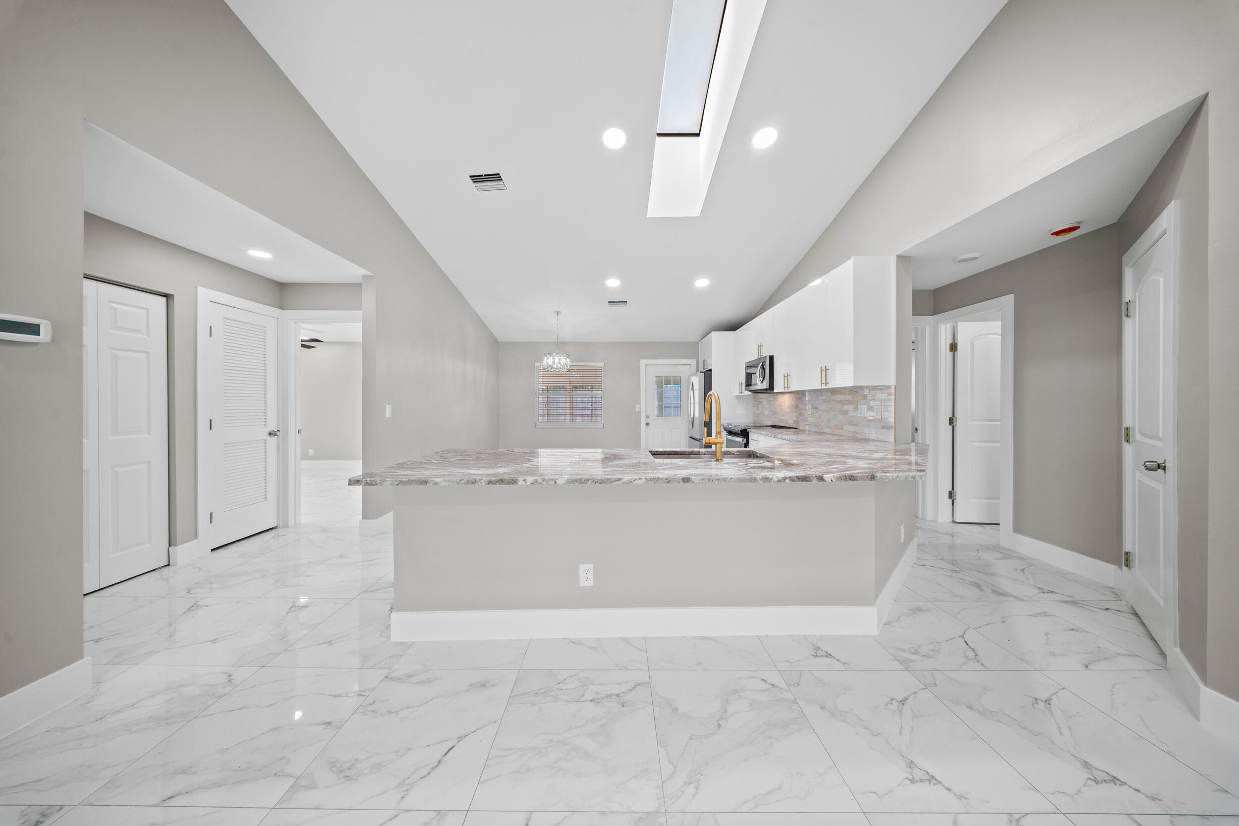 1627 Southeast Monroe Street Stuart, FL 34997 - Photo 6 of 33 a view of kitchen with kitchen island a sink stainless steel appliances cabinets and living room