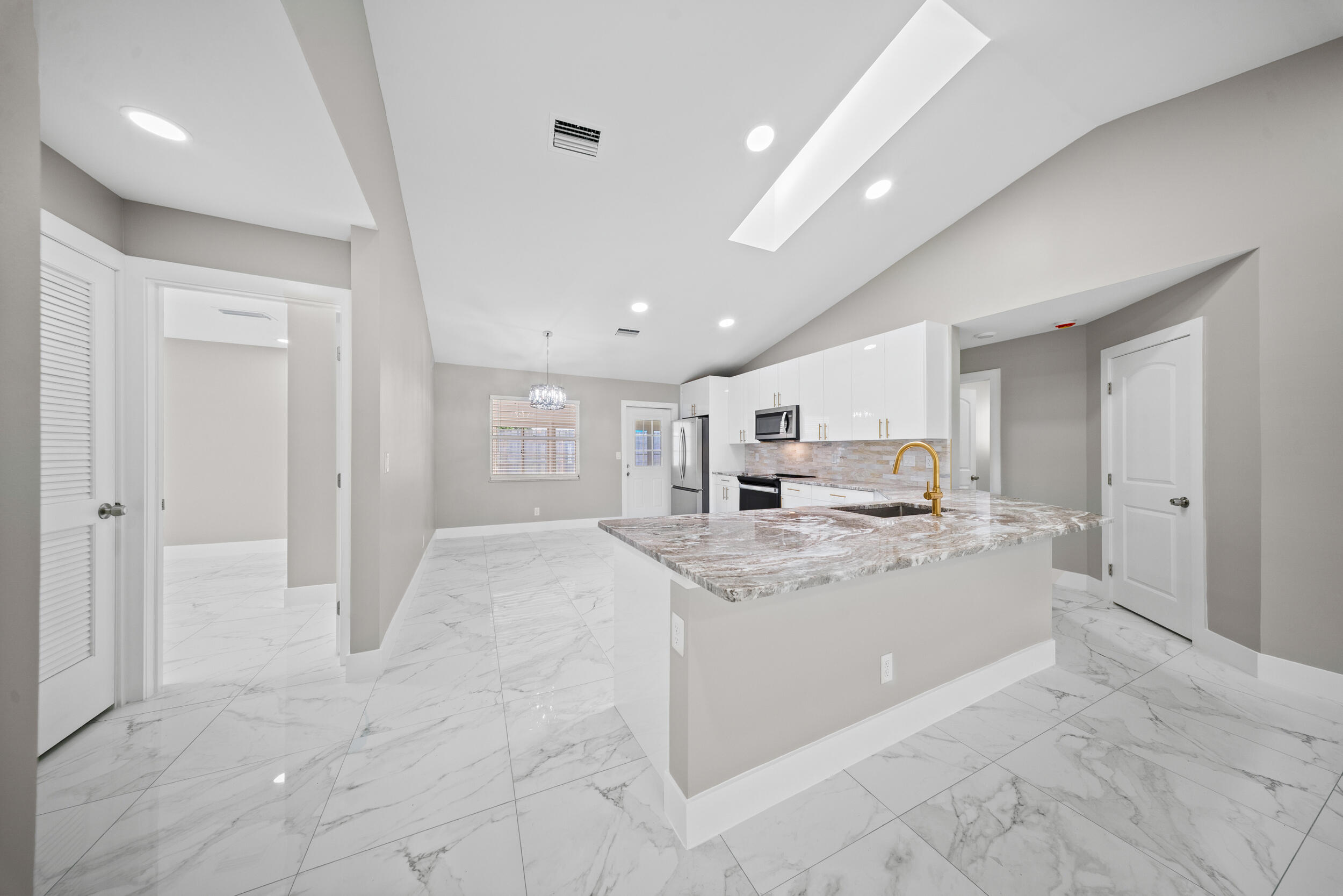 1627 Southeast Monroe Street Stuart, FL 34997 - Photo 8 of 33 a large white kitchen with a stove a sink a refrigerator and a cabinets