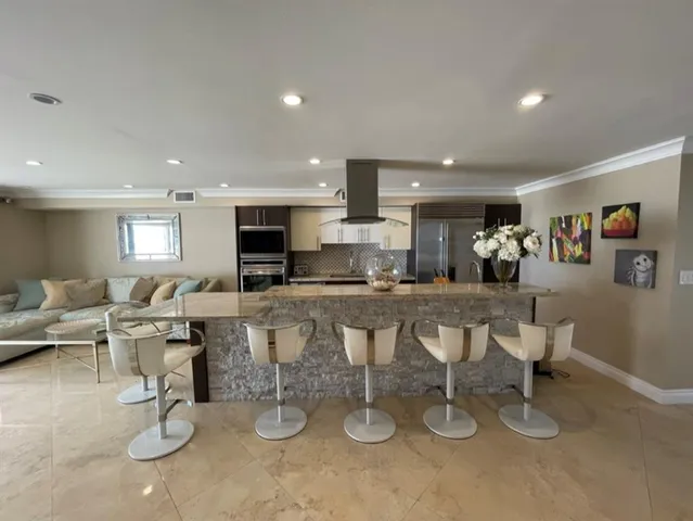 a living room with lots of furniture and kitchen view