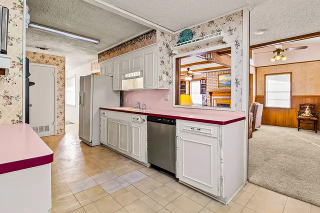 a utility room with stainless steel appliances kitchen island granite countertop a refrigerator and a stove
