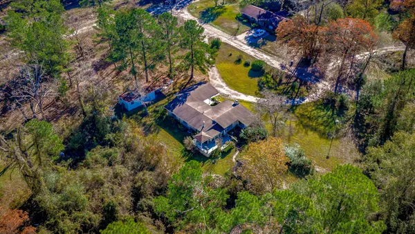 an aerial view of residential house with swimming pool and lawn chairs