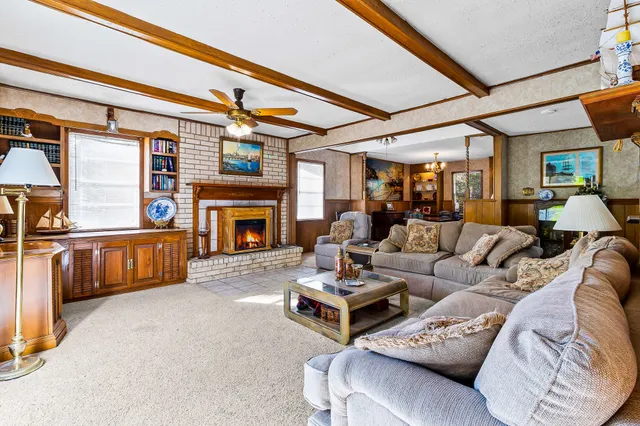 a living room with furniture and a ceiling fan