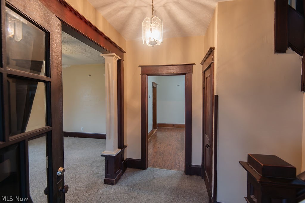 1195 South Johnson Road Sebring, OH 44672 - Photo 14 of 34 Hall with decorative columns, dark carpet, and hanging lights