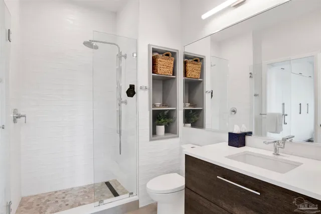 a bathroom with a sink a toilet and shower