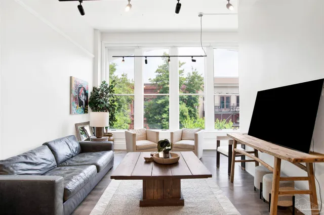 a living room with furniture a flat screen tv and a large window