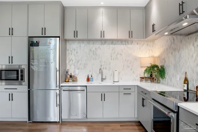 a kitchen with white cabinets and stainless steel appliances