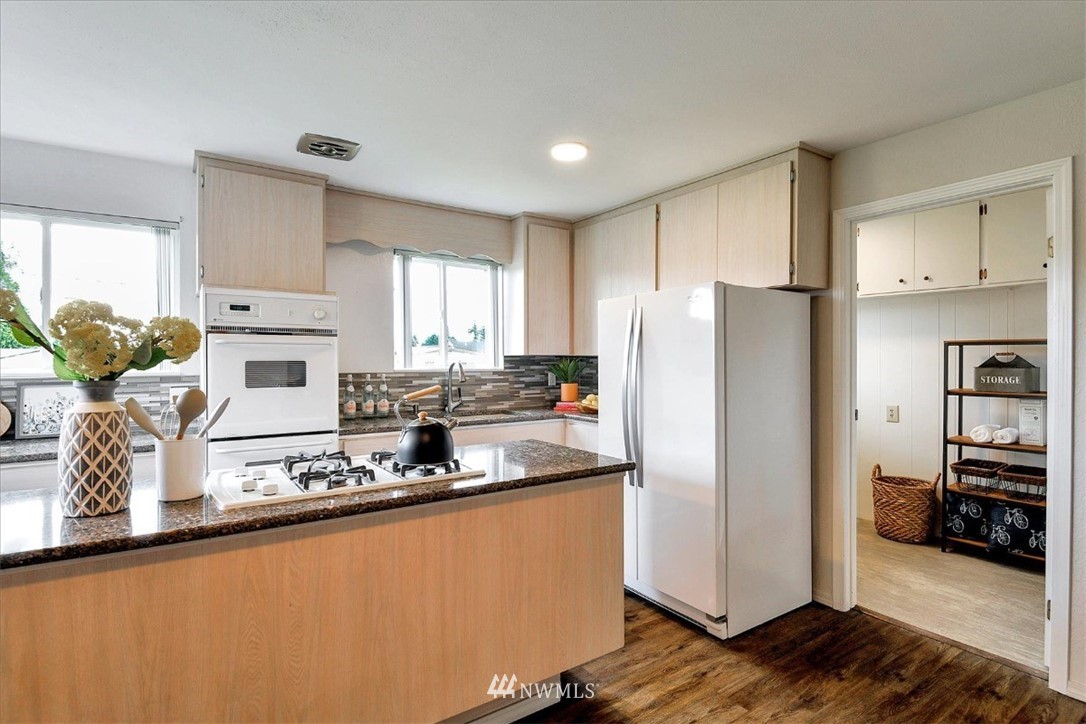 5202 Northeast 3rd Street Renton, WA 98059 - Photo 9 of 27 a kitchen with granite countertop a refrigerator and a sink