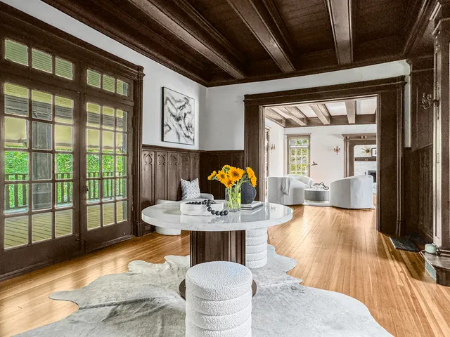 a dining room with furniture a chandelier and wooden floor