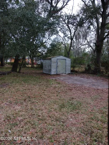 a view of a backyard with large trees