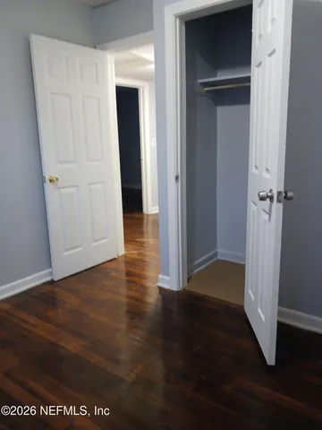 a view of a hallway with wooden floor