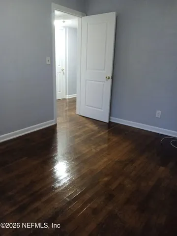 a view of room with wooden floor and windows