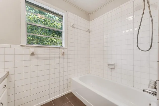 a bathroom with a bath tub with a shower