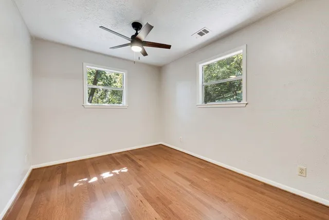 a view of empty room with wooden floor