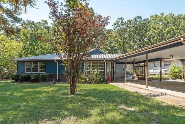 a backyard of a house with garden and outdoor seating