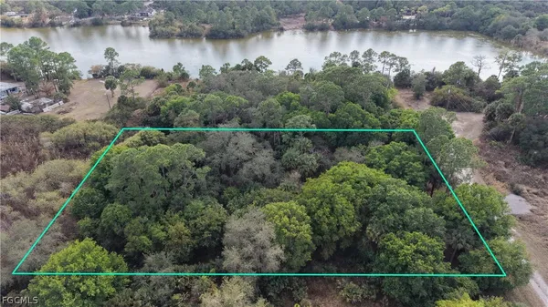 an aerial view of a house with a yard and lake view