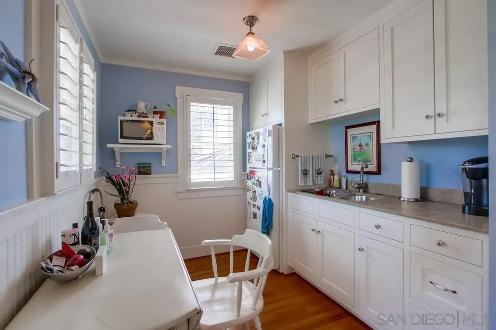 738 B Avenue Coronado, CA 92118 - Photo 24 of 25 a kitchen with white cabinets and window