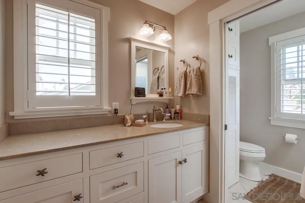 738 B Avenue Coronado, CA 92118 - Photo 25 of 25 a bathroom with a granite countertop sink mirror and window